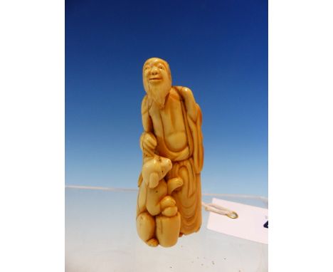 AN IVORY NETSUKE CARVED AS A BEARDED MAN STANDING WITH HIS RIGHT HAND GOING TO PAT THE HEAD OF HIS BEGGING DOG.   H 8cms