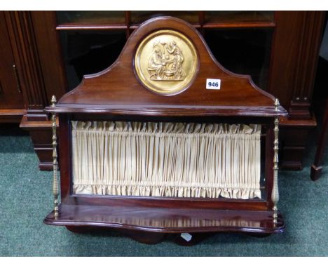 AN EDWARDIAN  MAHOGANY WALL SHELF, THE BACK TOPPED BY A CLASSICAL GILT METAL ROUNDEL OVER TWO SHELVES BACKED BY A BEIGE PLEAT