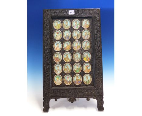 A COMPANY STYLE GROUP OF TWENTY FOUR PORTRAIT MINIATURES OF MOGUL EMPERORS SET IN A FLOWERING VINE CARVED EBONY EASEL BACKED 