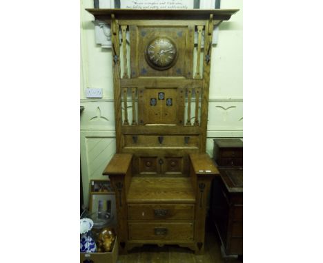 An oak and elm hall stand/chair, with Art Nouveau style inlaid decoration, and the back applied a clock, 122 cm wide Conditio