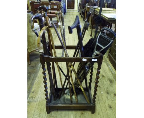 A silver top walking cane, two other silver mounted sticks, other sticks, a parasol and a stick stand (qty)