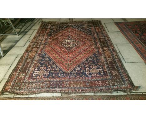 A Persian Qashqai carpet, 260 x 174 cm Condition report Report by NG

Worn, some threadbare patches.  End tassels cut.  Wear,