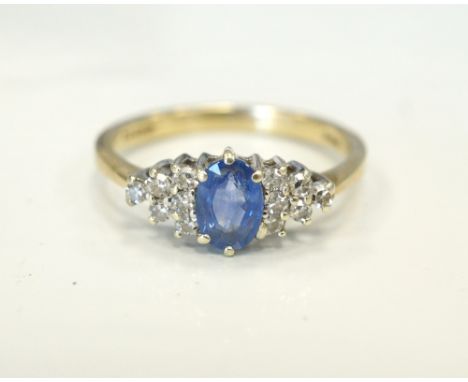 SAPPHIRE AND DIAMOND CLUSTER RINGthe central oval cut sapphire flanked by six diamonds to each side, on nine carat gold shank