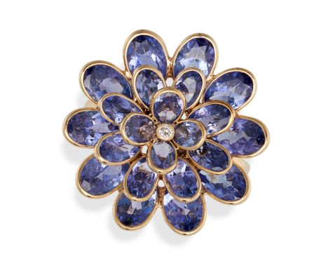 A TANZANITE AND DIAMOND FLOWER RING in 18ct yellow gold, set with a round brilliant cut diamond in a cluster of oval cut tanz