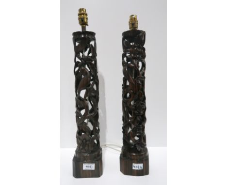 A pair of Chinese carved hardwood table lamps55cm high to top of fitting. The one to the left of the image has had quite subs