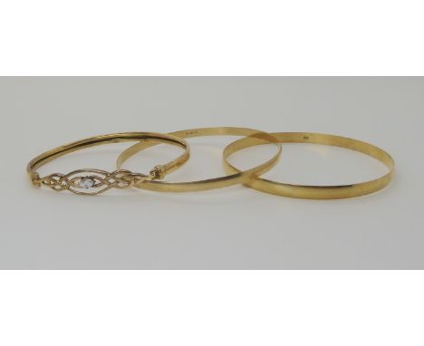 A 9ct gold celtic knotwork bangle set with a cz and two plain examples weight combined 15.7gms Condition Report: Cz Bangle mo