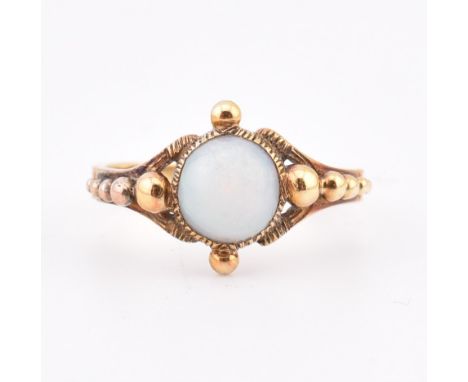 A Victorian opal ring. The antique ring having a single round collet set opal cabochon set in a decorative mount with metal b