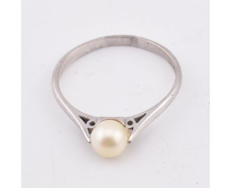 A hallmarked 18ct gold and pearl ring. The 18ct white gold ring set with a single round pearl to chenier shoulders and polish