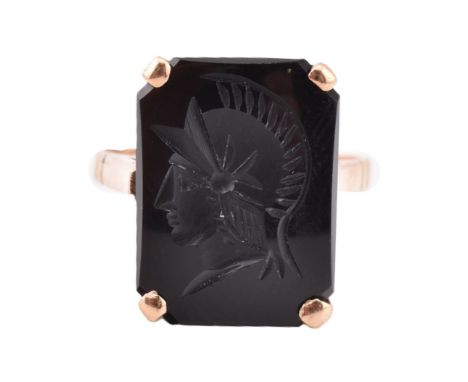 A 9ct gold and onyx Roman soldier intaglio ring. The 9ct yellow gold ring set with onyx carved with a Roman soldier intaglio 