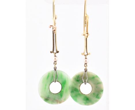 A pair of gold and jade pendant earrings. The pendant earrings having an annular jade pendant surmounted by a round pearl to 