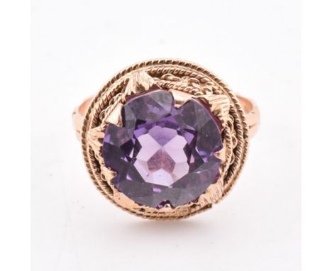 An 18ct gold and synthetic colour change sapphire ring. The ring having a single round cut synthetic colour change sapphire s