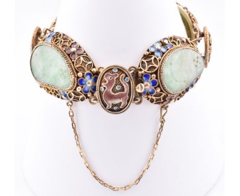 A silver, jade and enamel bracelet. The panel bracelet comprised of four links having carved jade set within decorative metal