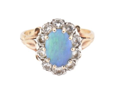 A hallmarked 9ct gold, opal and diamond cluster ring. The 9ct yellow gold ring set with a central oval opal cabochon surround