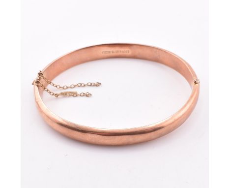 A hallmarked 9ct gold hinged bangle. The early 20th century 9ct rose gold bangle hinged bangle having a concealed box clasp. 