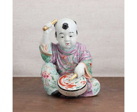 A Chinese famille rose figure,20th century, of a seated boy playing a drum, 24.5cm highCondition ReportEnamel and gilt losses
