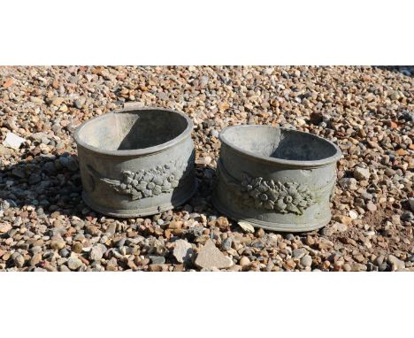 A pair of small circular lead planters,in the Neoclassical taste,76cm diameter,15cm high,together with an oval planter,62.5cm