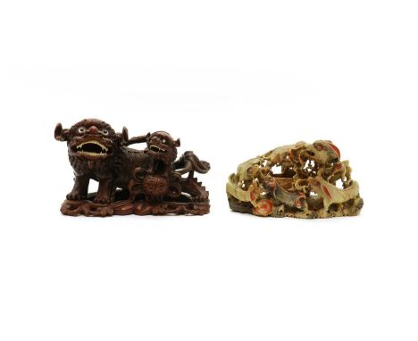 A Chinese wood carving,20th century, of Buddhist lions playing a brocade ball with a pup, 29.5cm long, anda soapstone carving