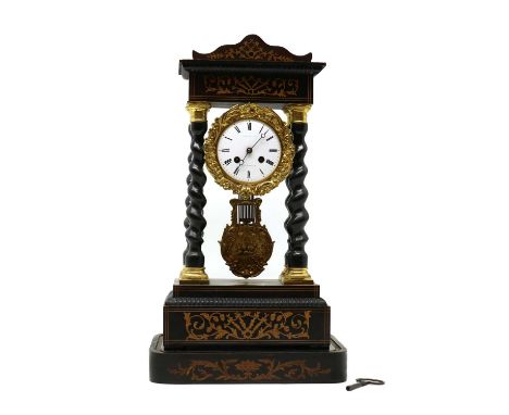 A Victorian ebonised portico clock,with a signed white enamel dial enclosed with a gilt metal surround and barley twist colum