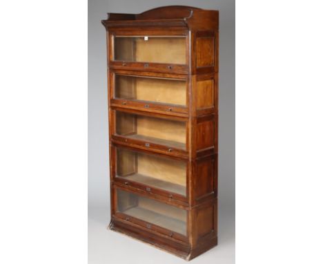An early 20th century Lebus mahogany five-tier sectional bookcase, having shaped tray-top, each tier enclosed by a glass slid