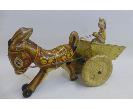 A Marx Toys clockwork tinplate model of a donkey pulling a cart with a figure inside. 