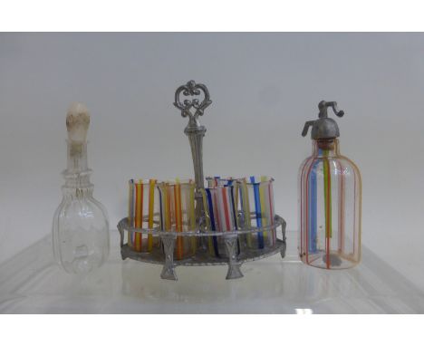 A miniature multi-coloured glass soda siphon and a similar metal six glass carrier, all with multi-coloured glass tumblers an
