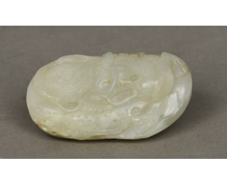 A Chinese carved jade pebble
Worked with a mythical beast.  7 cm wide. CONDITION REPORTS: Generally in good condition, expect
