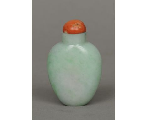A Chinese pale apple green carved jade snuff bottle 
With red coral stopper.  6.5 cm high. CONDITION REPORTS: Generally in go
