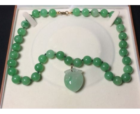 A carved jade bead necklace with peach carved pendant
The necklace approximately 56.5 cm long.
 CONDITION REPORTS: Generally 