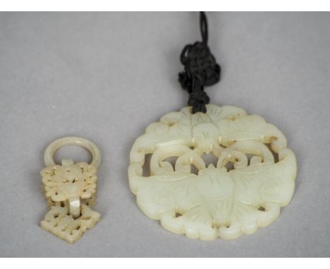 A Chinese carved jade bi disc
Worked and pierced as two butterflies; together with a carved and pierced jade articulated pend