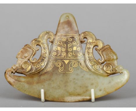 A carved russet jade pendant
Of axe form, carved with mermen and gilt decorated.  14 cm wide. CONDITION REPORTS: Generally in