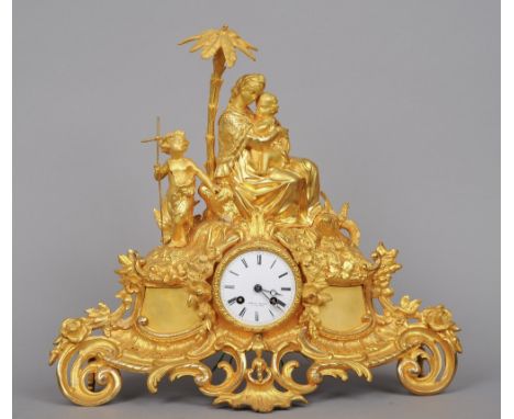 A 19th century gilt metal mantel clock
Surmounted with the Virgin and Child and a Baptist child, the white enamel dial inscri