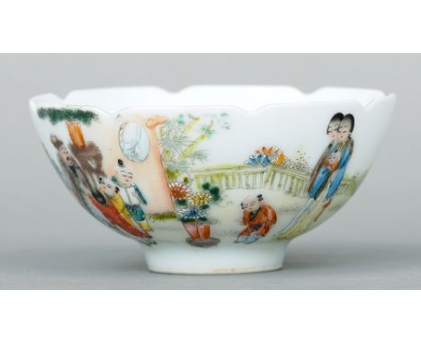 A Chinese porcelain bowl
With lappet moulded rim, the body decorated with figures and children within a garden, blue painted 