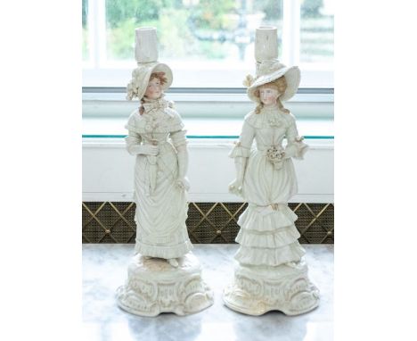 A pair of late 19th century European ceramic candlesticks, in the form of two women with flowers, some gilt decoration 43.5cm