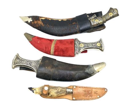 A mid to late 20th century Khukuri knife in a worn leather scabbard with two sharpening knives, together with two jambiya kni