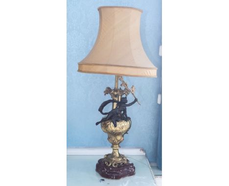 A large pair of early to mid 20th century bedside light, rococo style, gilt metal with ebonies cherubs, on marble bases, 95cm