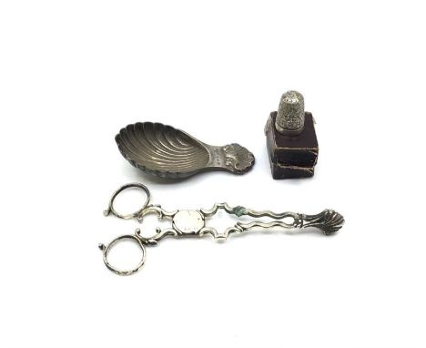 A silver scalloped caddy spoon, London 1969, together with a pair of silver sugar tongs and a hallmarked silver thimble in a 