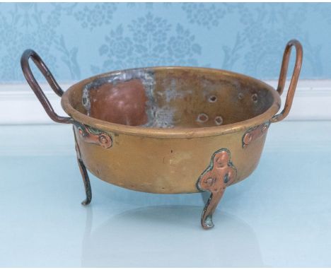 A late 19th century small brass cauldron with copper handles and feet Please note this item is at an offsite location, buyers