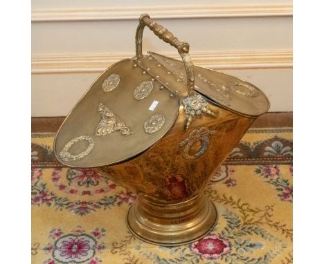 A brass coal scuttle, carrying handle with two opening lids, on a circular stepped base 57cm H x 57cm W x 33cm DPlease note t