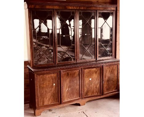 A George III revival mahogany library bookcase, in a Chippendale design, moulded on dental cornice, above four astragal glaze