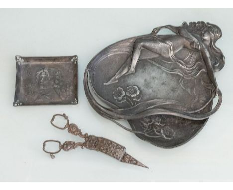 An art deco pewter tray, with a reclining lady in a heart shape, together with a smaller art deco style rectangular tray and 