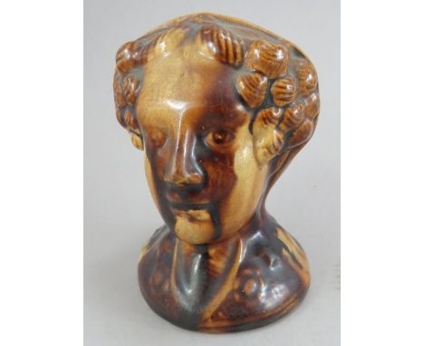 An early nineteenth century pottery treacle-glazed sash window rest, possibly Rockingham, c. 1820. It is of moulded, modelled