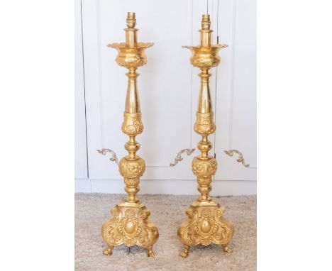 Two large early to mid 20th century gilt metal lamp columns, swag designs, each raised on three paw feet, 87cm high (2)Please