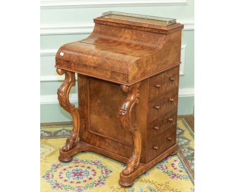 An early Victorian burr walnut Davenport desk, circa 1850, three quarter brass pierced gallery, the lift up top enclosing two