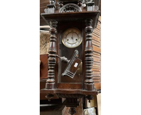An early 20th century mahogany wall mounted clock with wooden and brass pendulum, white enamel dial with Arabic numerals, the