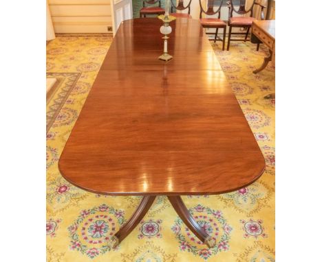A 19th century mahogany extending triple pedestal dining room table, with three removable leaves, raised on brass paw feet an
