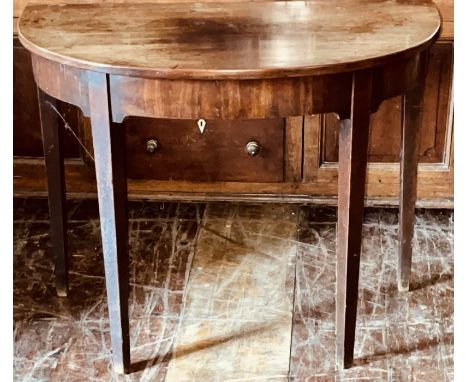A George III mahogany demi-lune console table, circa 1800, manner of George Hepplewhite, slight oversailing top, arch carved 