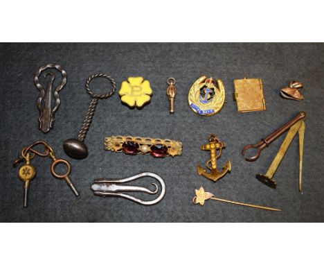 A vintage tin containing steel folding button hooks, a pipe tamper, a multi tool pipe set, etc.