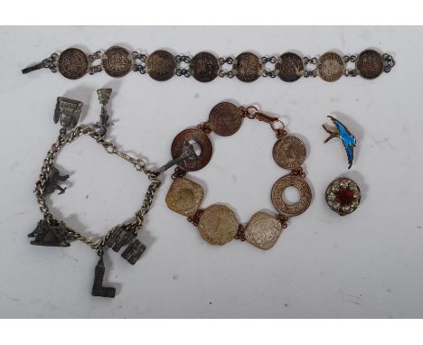 2 silver and white metal coin bracelets to include overseas coins together with an enamel brooch in the form of a swallow and