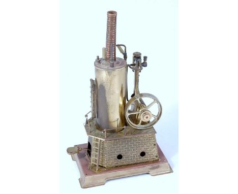 A Wilesco solid brass vertical steam engine, comprising brickwork housed vertical boiler powering a single cylinder vertical 