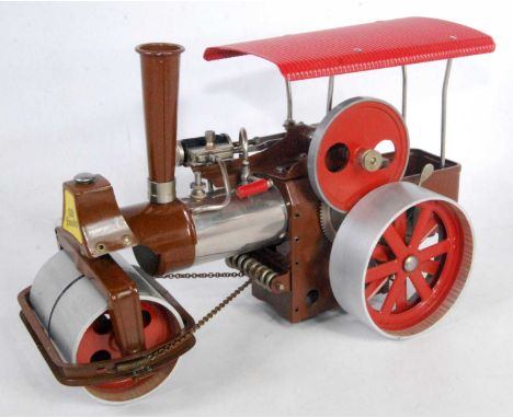 A Wilesco Old Smoky steam roller finished in brown base metal and red with burner and canopy, loose example, hard to find in 